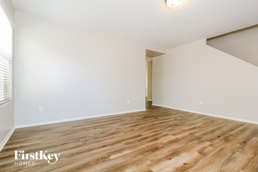 an empty living room with wood flooring and white walls