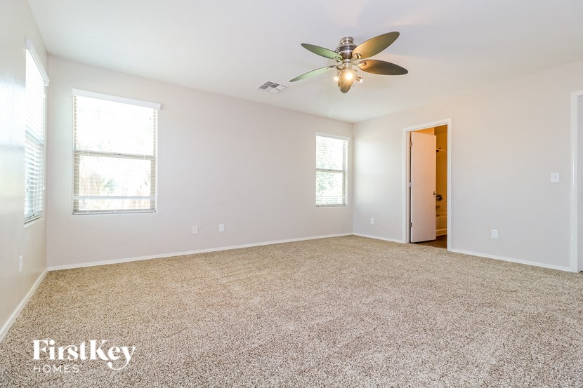 a empty living room with a ceiling fan