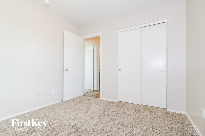 a bedroom with white closets and a carpeted floor