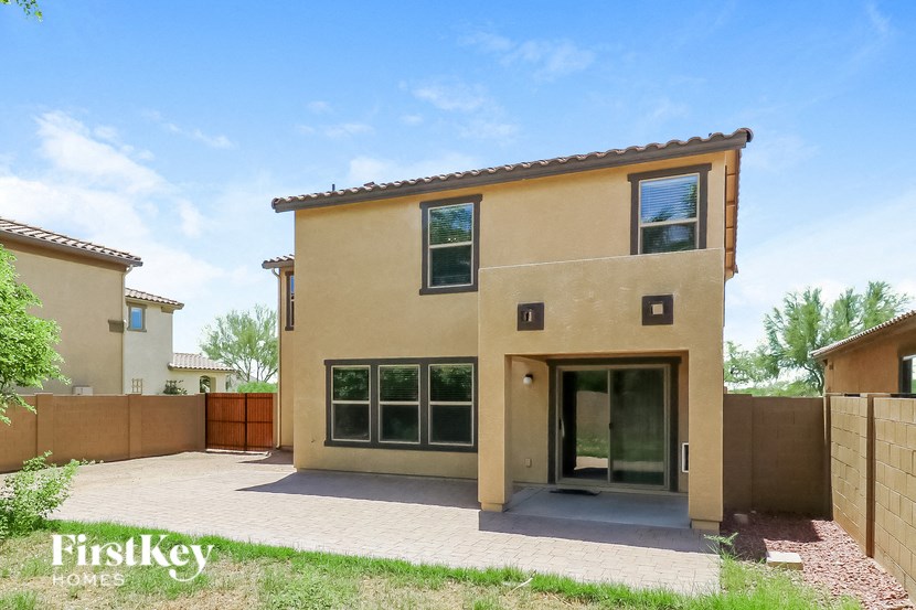 a beige house with a driveway and a gate