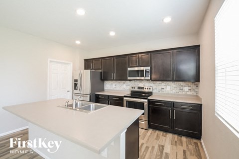 a kitchen with black cabinets and a white counter top