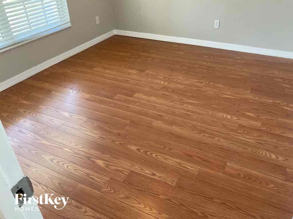 A room with wooden flooring and a window.