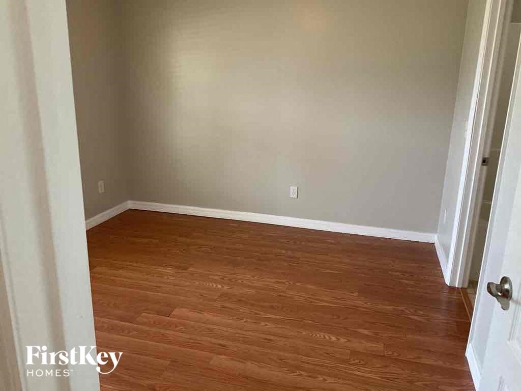 A room with wooden flooring and a white door.