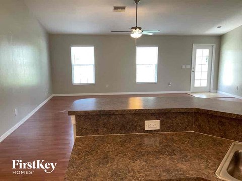 A kitchen with a brown counter top and a ceiling fan.