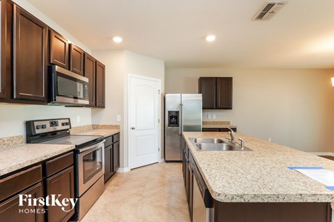 A kitchen with brown cabinets and a granite countertop.