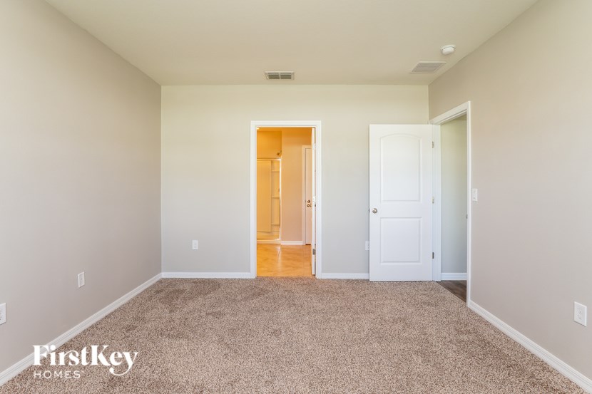 A room with a carpeted floor and a doorway leading to another room.