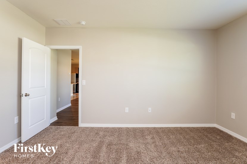 A room with a carpeted floor and a doorway leading to another room.