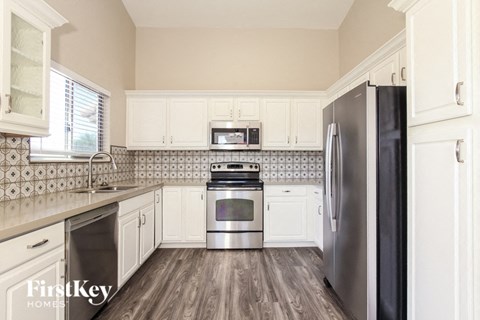 a kitchen with stainless steel appliances and white cabinets