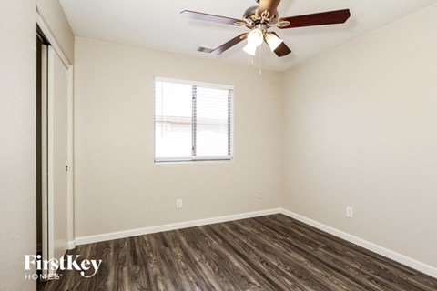 a bedroom with a ceiling fan and a window
