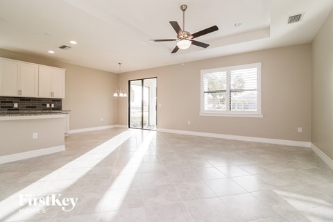 an empty kitchen and living room with a ceiling fan
