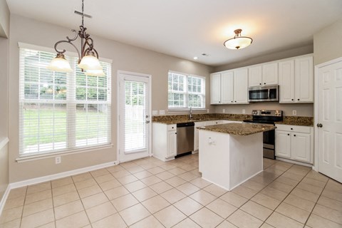 a kitchen with white cabinets and a counter top