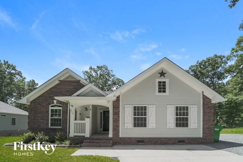 a white house with a white front porch and a star on the roof