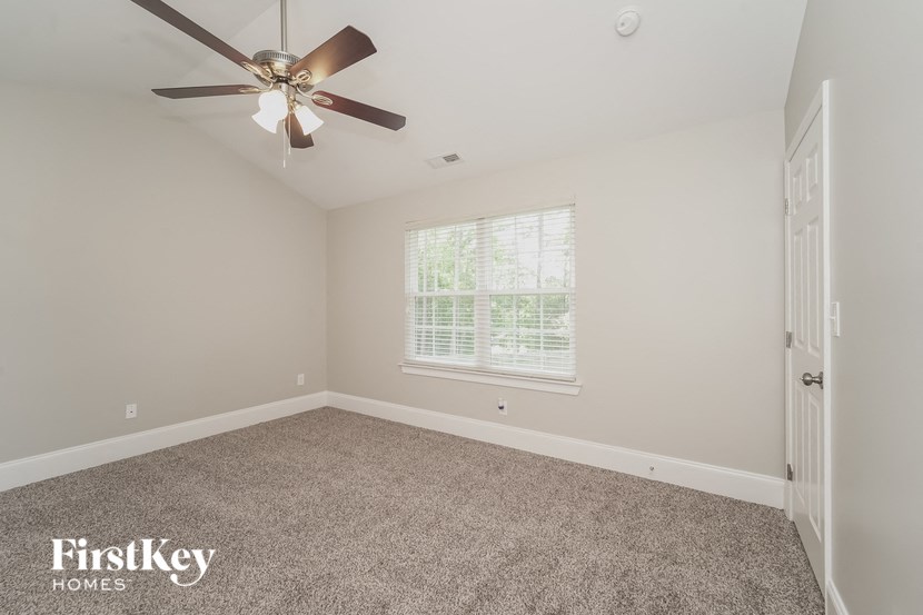 the master bedroom has a ceiling fan and carpeted flooring