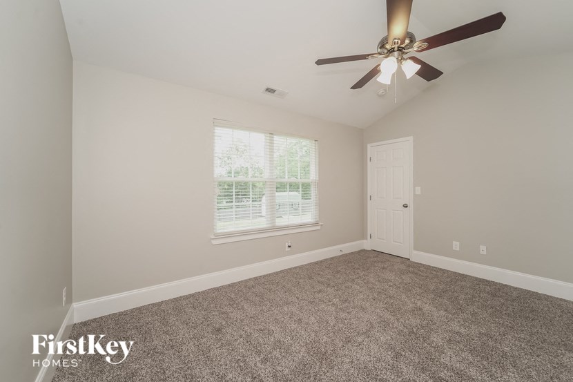 a bedroom with carpet and a ceiling fan