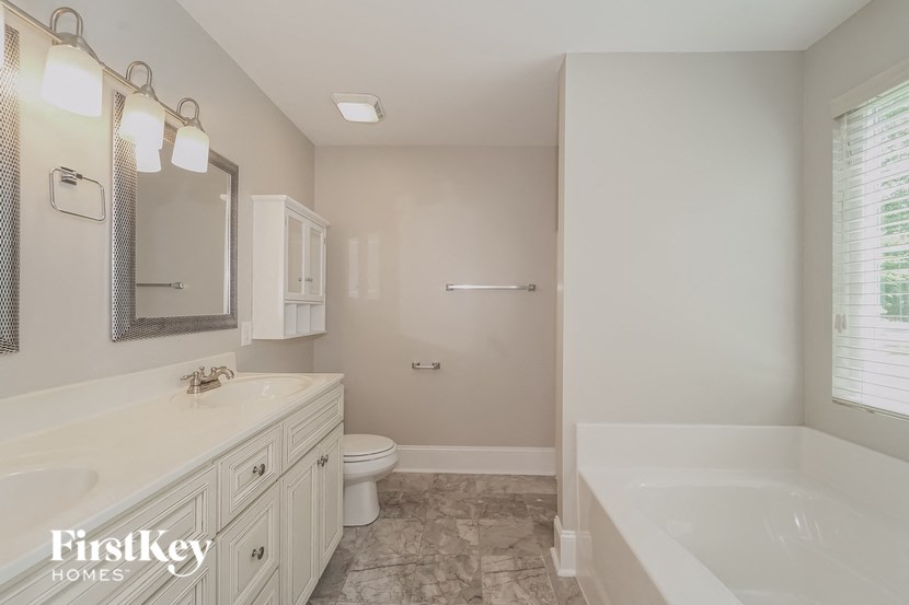 a white bathroom with a tub and a sink and a toilet