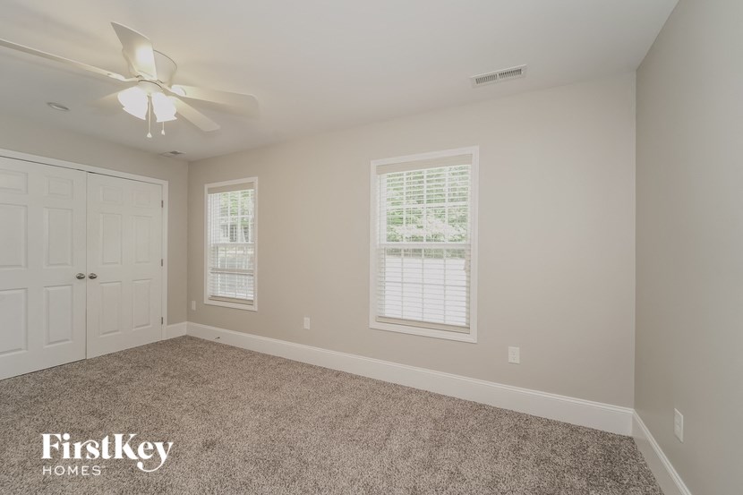 a bedroom with a ceiling fan and a white door
