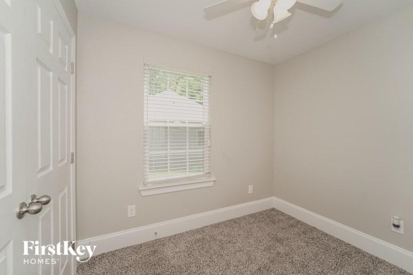 a bedroom with a ceiling fan and a window