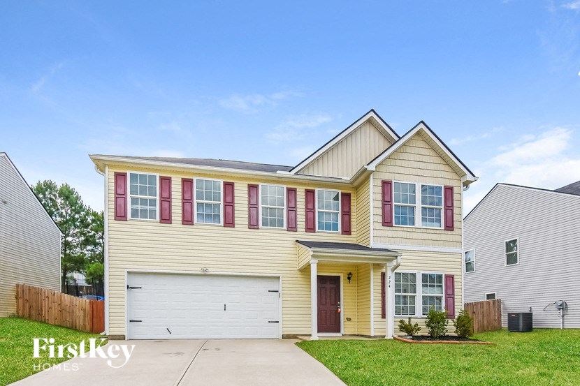 a yellow house with red shutters and a white garage door