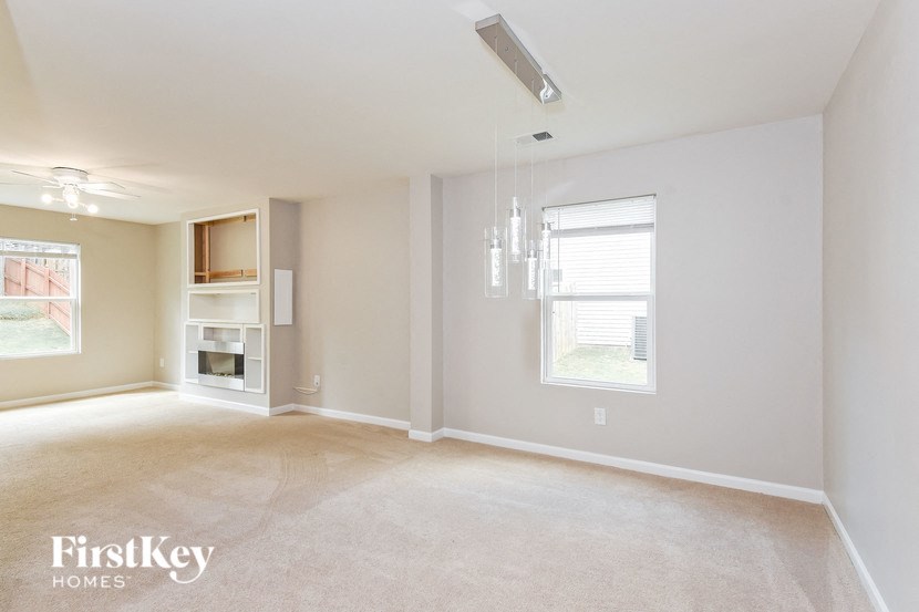 an empty living room with a fireplace and a chandelier