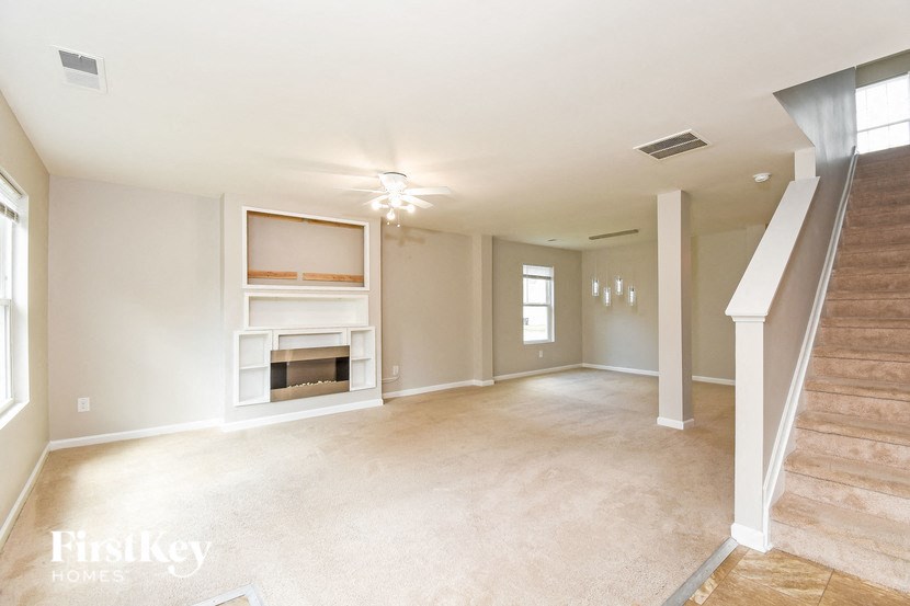 a empty living room with a fireplace and a staircase