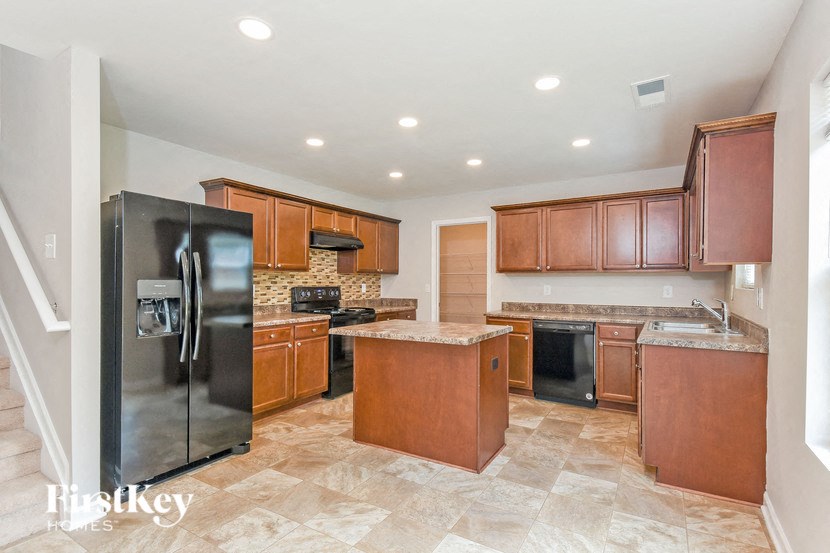 a large kitchen with stainless steel appliances and wooden cabinets