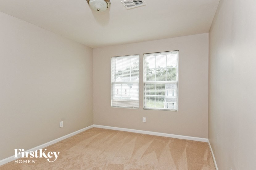 a room with two windows and a wooden floor