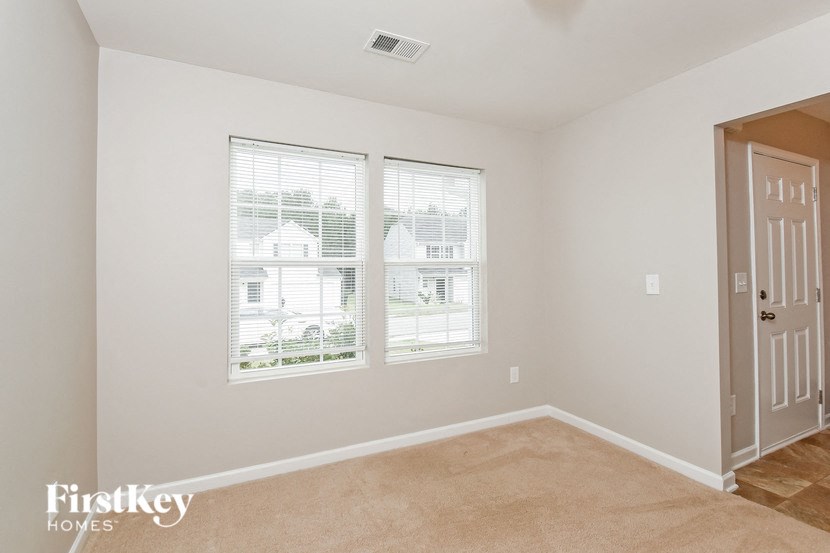 a bedroom with two windows and a door and a carpeted floor
