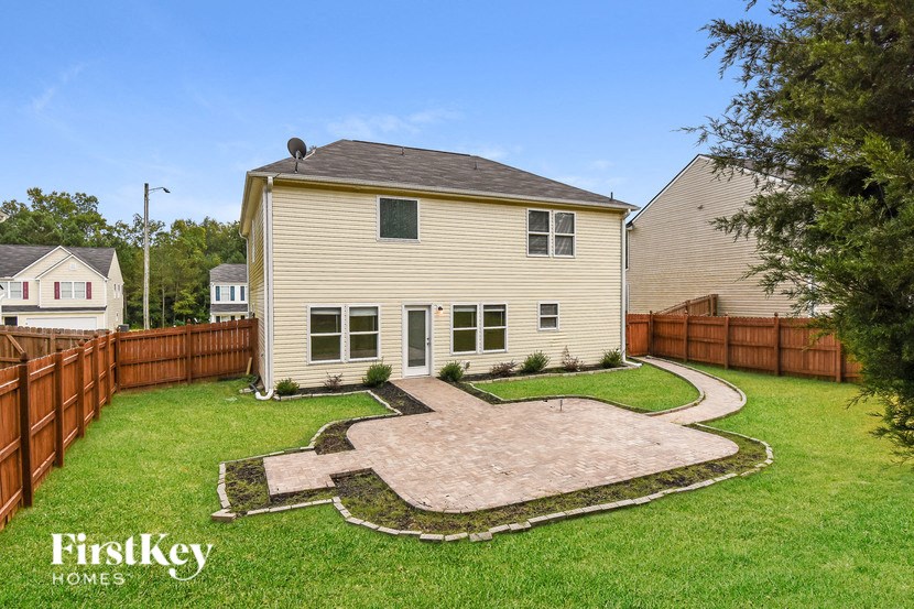 a backyard with a house and a yard with a patio