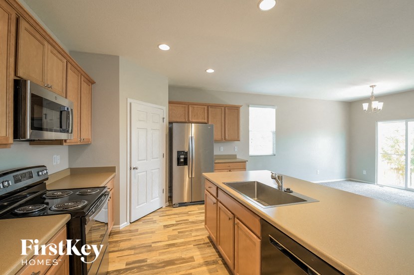 A kitchen with wooden cabinets and a stainless steel refrigerator.