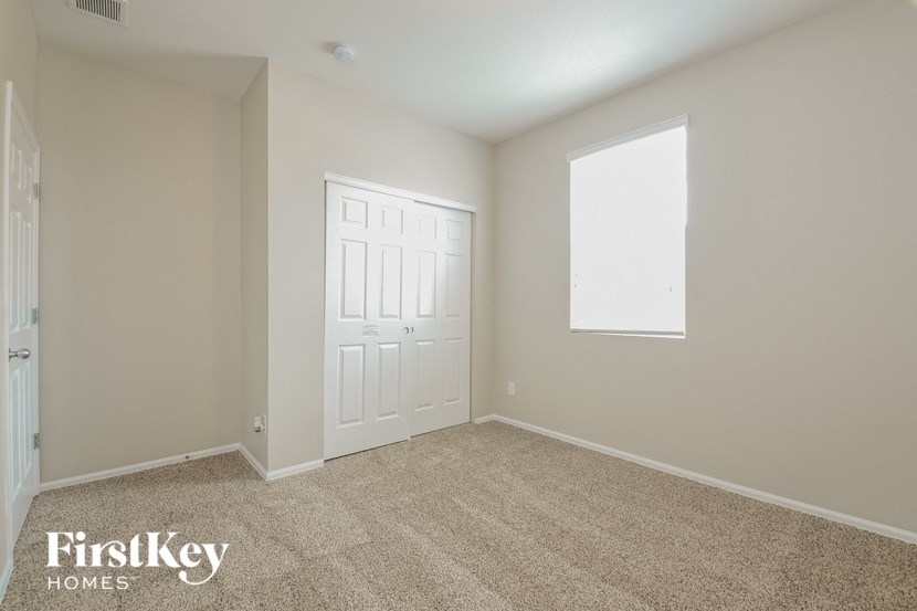A room with a carpeted floor and a door.