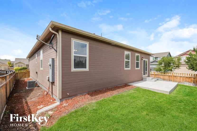 A house with a brown siding and a white door is for sale.