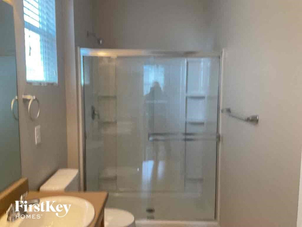 A bathroom with a walk in shower and a toilet.