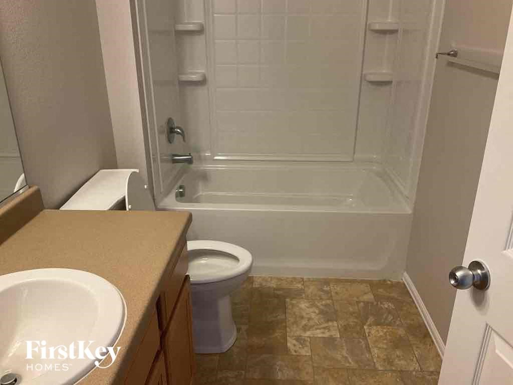 A bathroom with a toilet, sink, and walk-in shower.