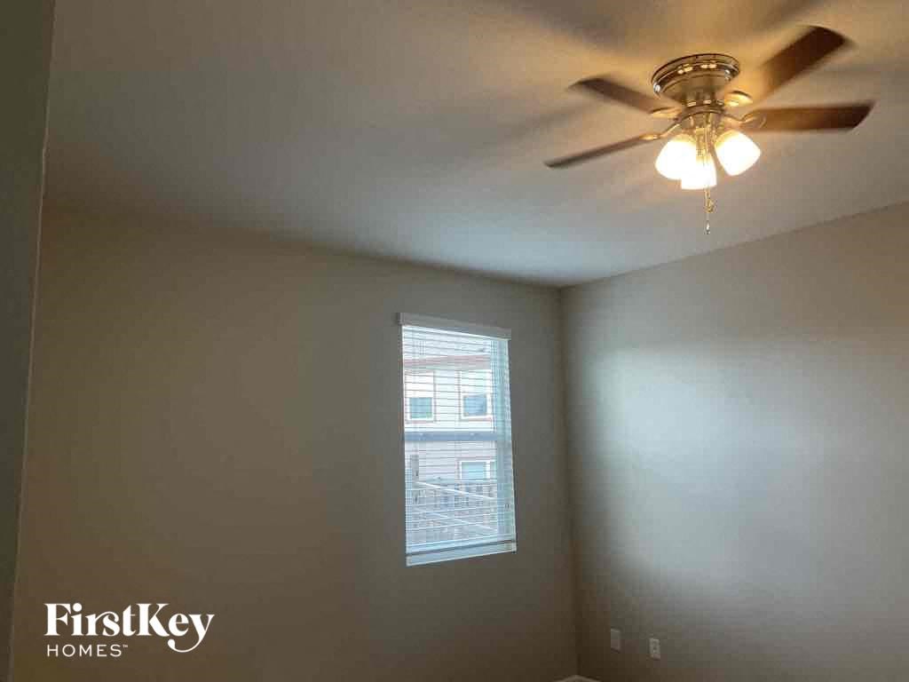 A room with a ceiling fan and a window.