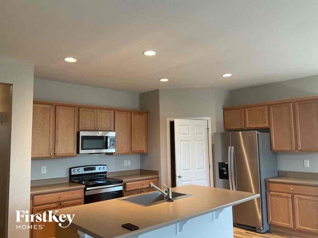 A kitchen with wooden cabinets and a stainless steel refrigerator.