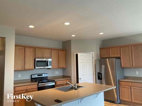 A kitchen with wooden cabinets and a stainless steel refrigerator.