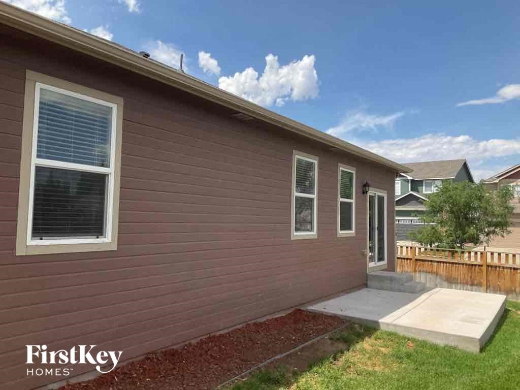 A house with a brown siding and a white window is for sale.