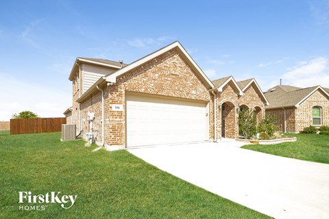 a house with a white garage door in front of a lawn