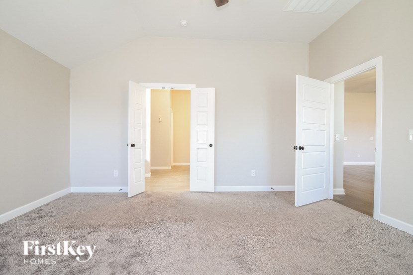 a bedroom with two doors and a carpeted floor