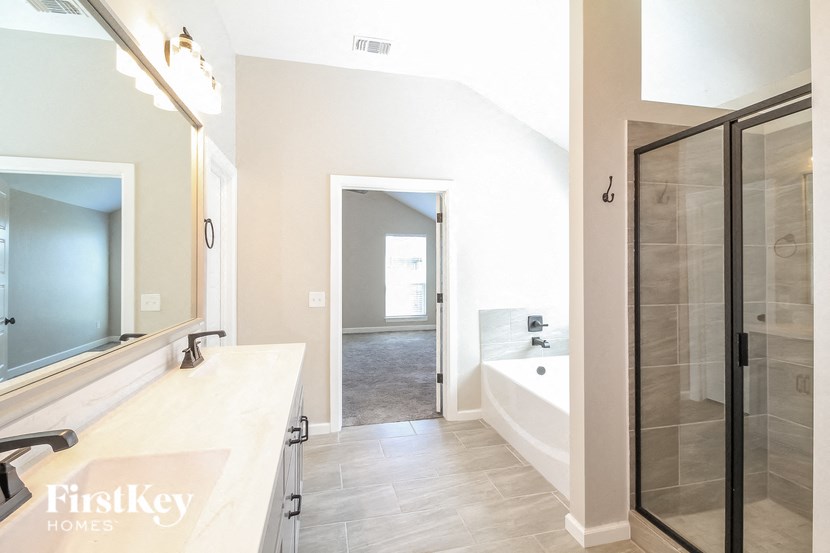 a bathroom with a shower and a sink and a mirror