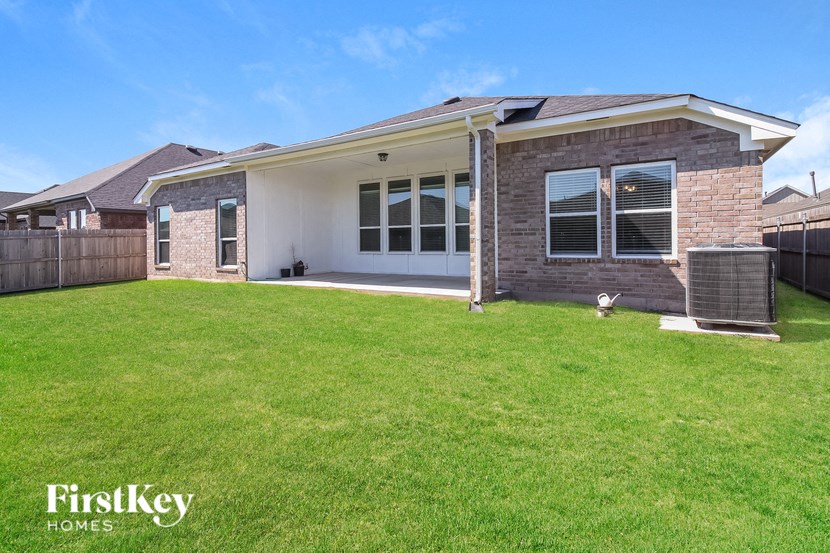 a backyard with a lawn and a brick house