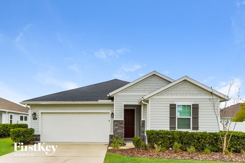 a white house with a yard and a blue sky