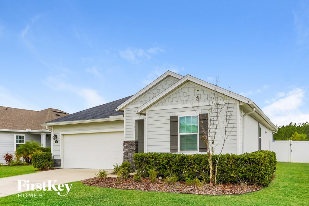 a white house with a lawn and a blue sky