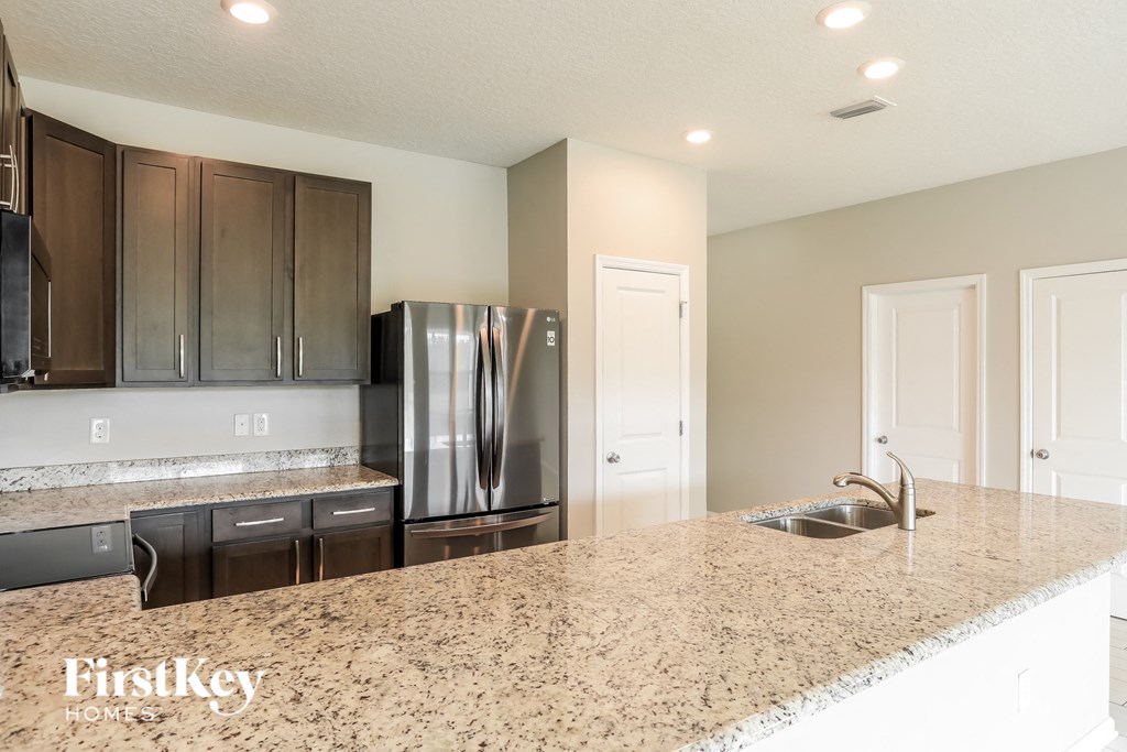 a kitchen with a granite counter top and a stainless steel refrigerator