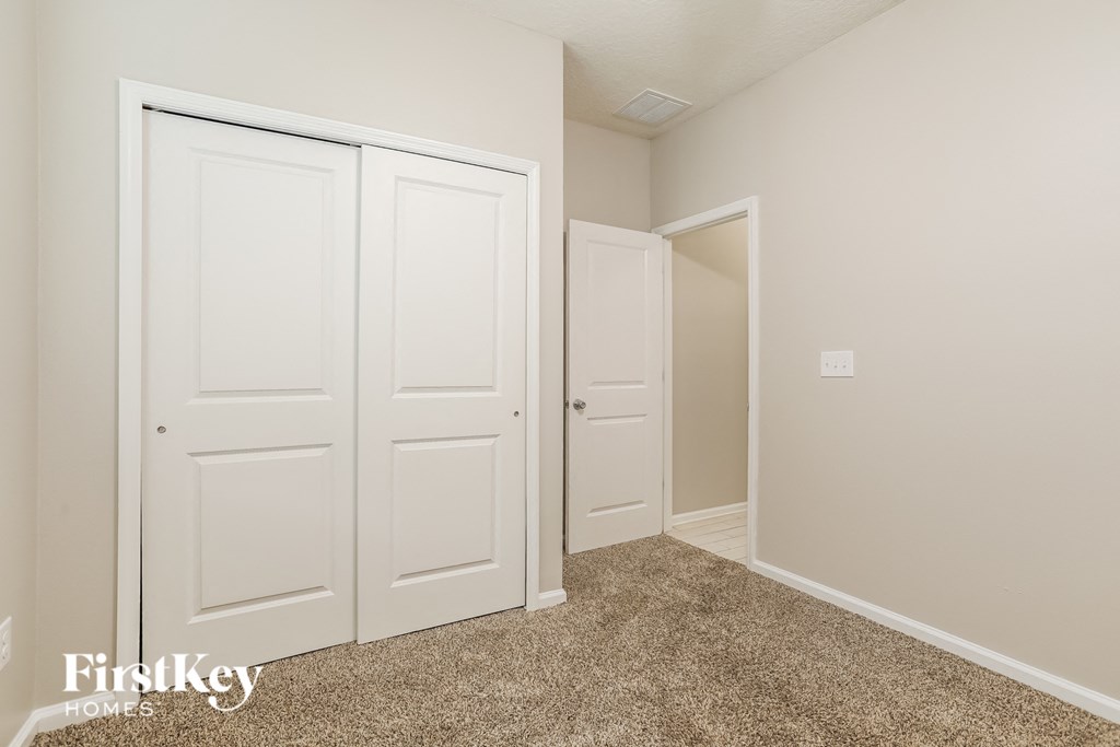 a bedroom with two closets and a door to a hallway