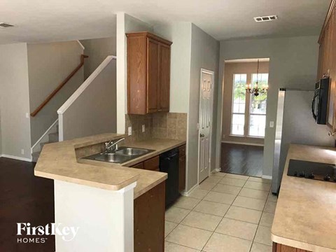 A kitchen with a sink and a refrigerator.