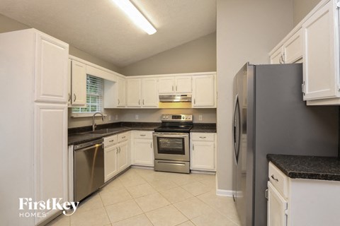 A kitchen with white cabinets and stainless steel appliances.