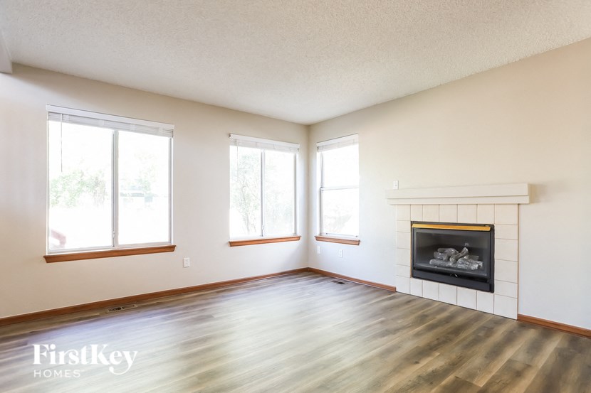 a living room with a fireplace and a wooden floor