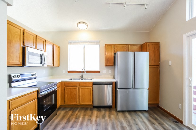an empty kitchen with wooden cabinets and stainless steel appliances