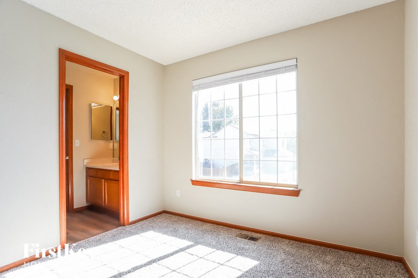 an empty room with a window and a door to a bathroom